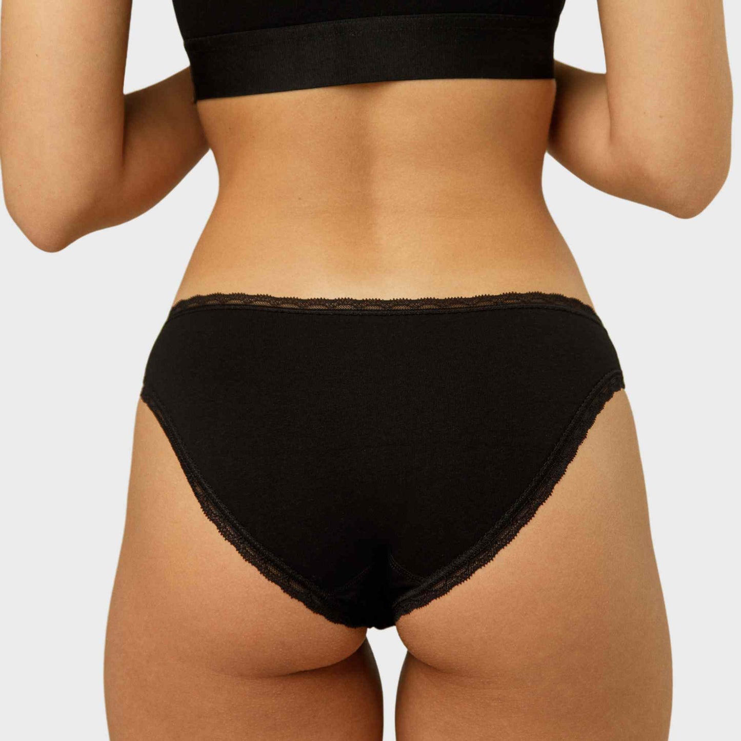 Rear view of a woman wearing black bikini briefs
