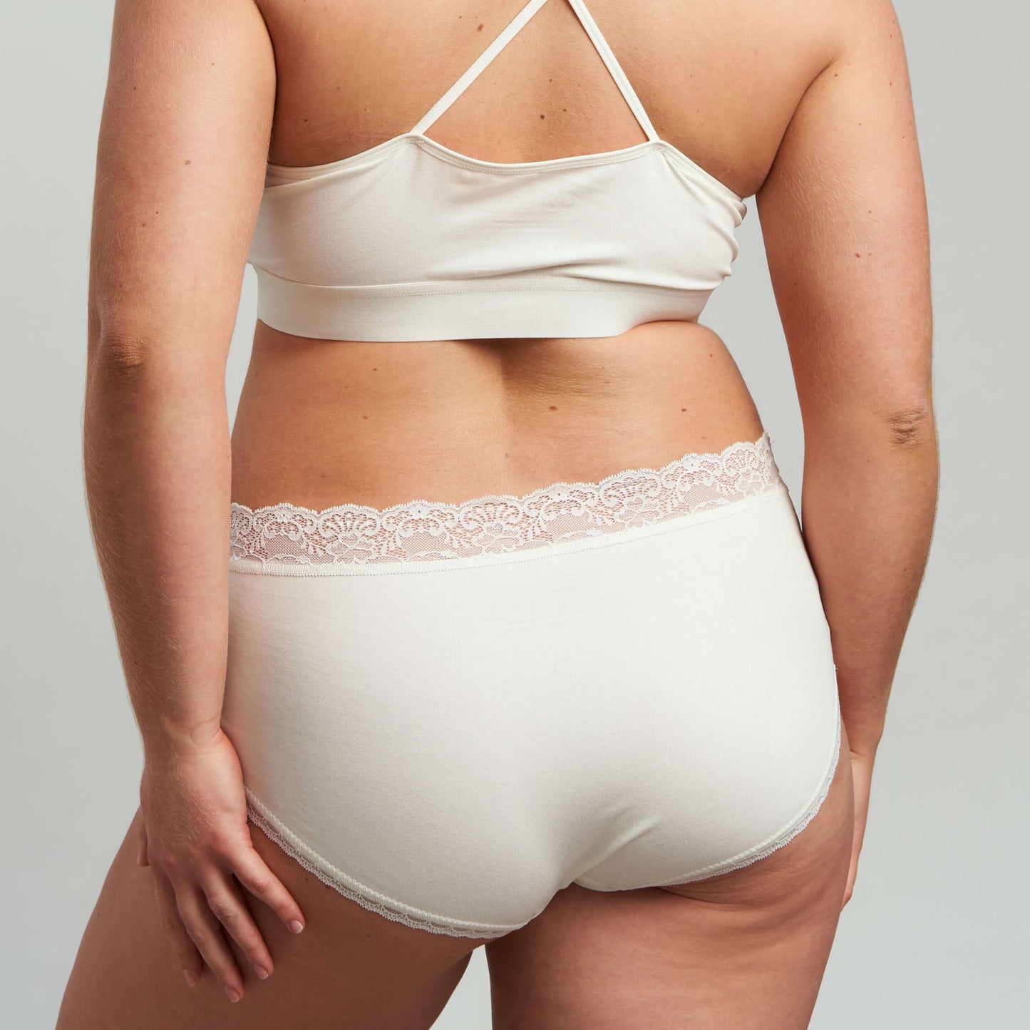 Rear view of a woman wearing white hipster underwear